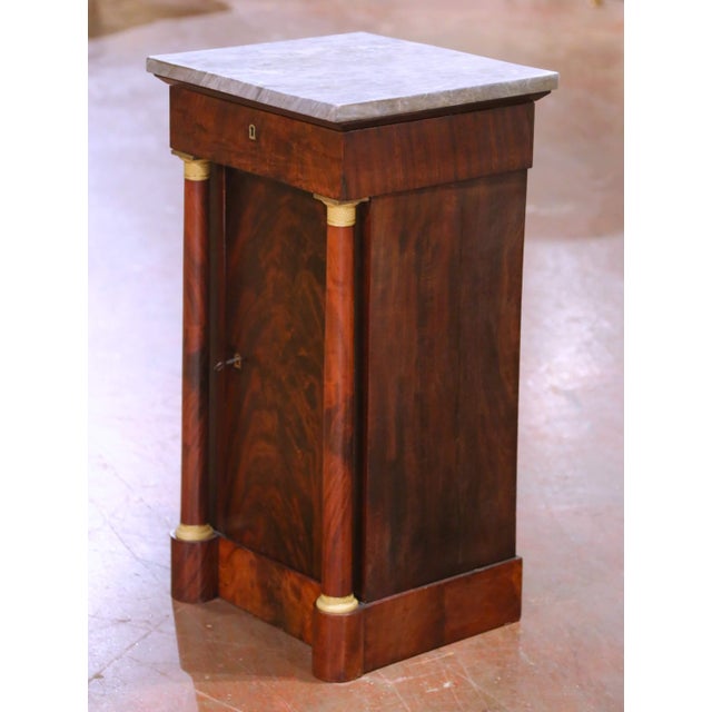 This elegant fruitwood cabinet, crafted in France circa 1860, exemplifies classic Empire style. The antique vanity is...