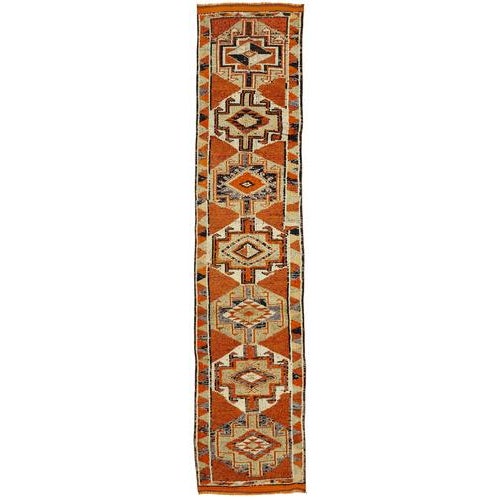 This exquisite runner rug is a rare example of tribal craftsmanship, hand-knotted by the women of the Herki tribe during...
