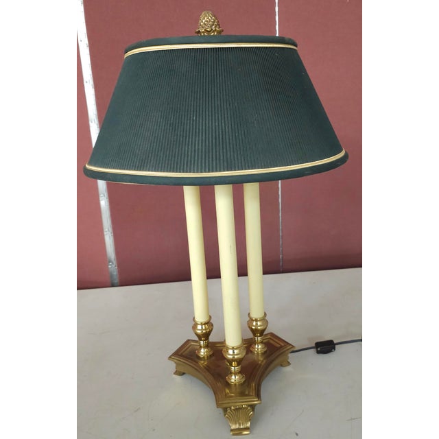 A Stiffel sryle brass triple bouillotte table lamp featuring a dark green shade Style: Regency/French Empire, featuring a...