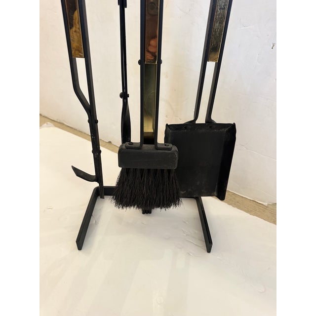 Elegant set of mid-century modern iron and brass fireplace tools.