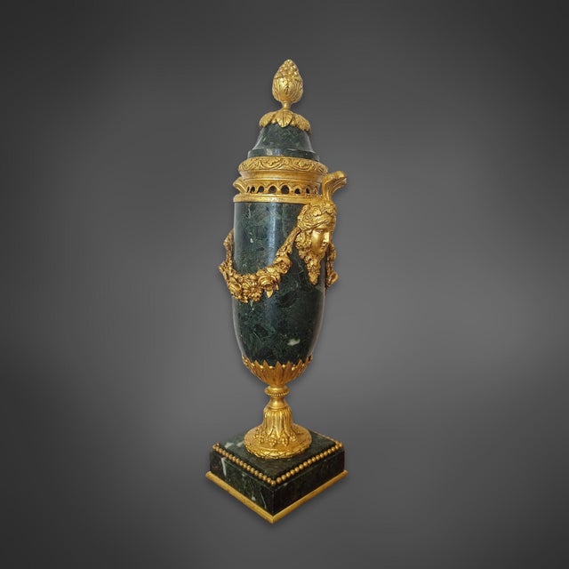 A pair of cassolettes made of green marble with gilt bronze mounts. The stone has a dark green base color with light, wavy...