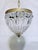 Add a touch of timeless, romantic glamour to your space with this exquisite vintage mid-century tiered brass crystal...