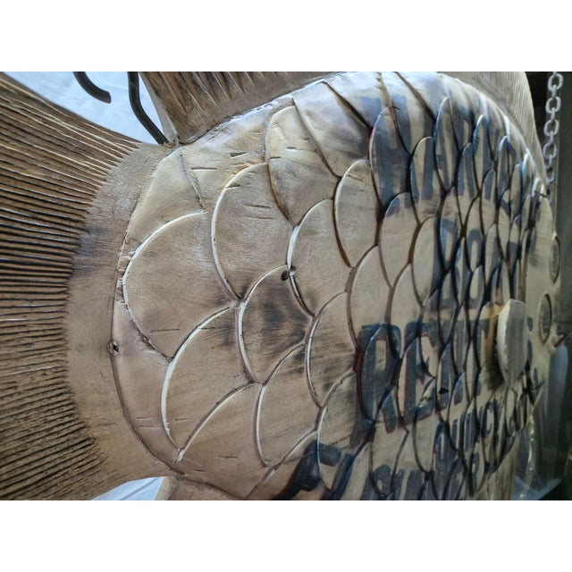 "Harvey's Boat Rentals, Quincy, Flounder Capital" is painted on this carved flounder. Details include carved scales, fins,...