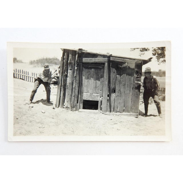 Circa 1940's sepia toned snapshot photograph of two men dressed up as a wild west outlaw or sheriff. With pair of real...