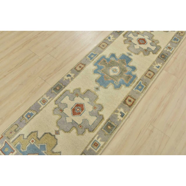 This tribal geometric Anatolia runner is hand-knotted with an all-wool pile on a cotton foundation. This rug is new and in...