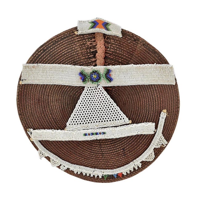Married Zulu women always keep their heads covered in public. For ceremonial occasions, they wear elaborately woven red...