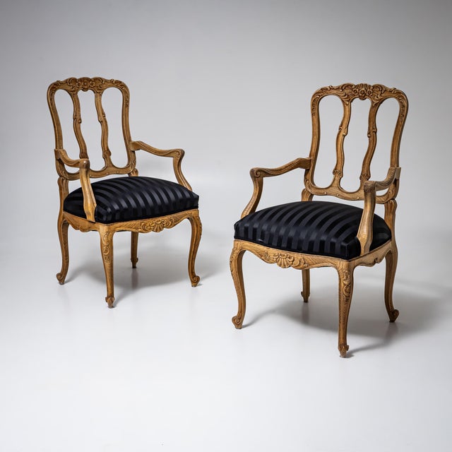 Set of six carved solid oak side chairs and two armchairs, newly upholstered in a black striped fabric. The openwork backs...