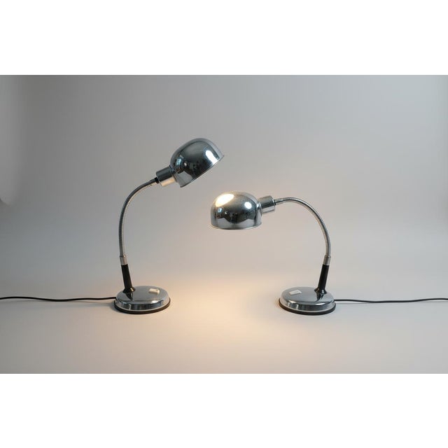 A pair of chrome-plated desk lamps with stainless steel bases from the 1970's made in Italy, these goose neck style lamps...