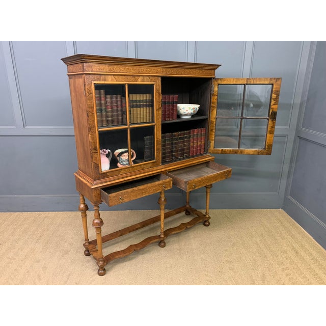 A charming burr walnut cabinet (or bookcase) on stand in the William and Mary style. Dating to the early 20th century and...