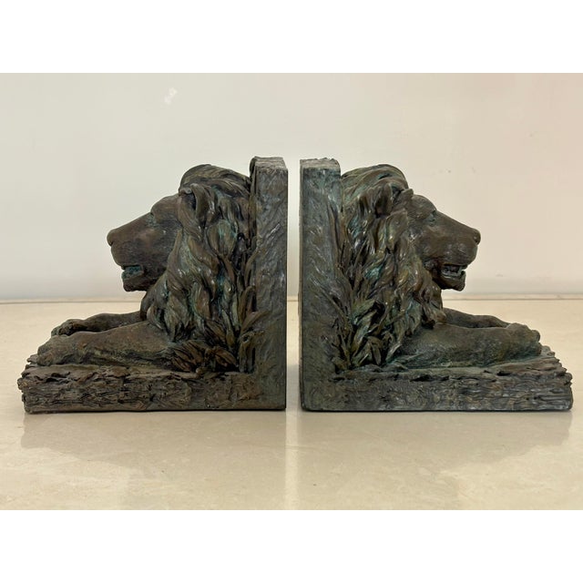 Distinguished pair of lion bookends made of resin and richly finished with the look of aged bronze with verdigris. From a...