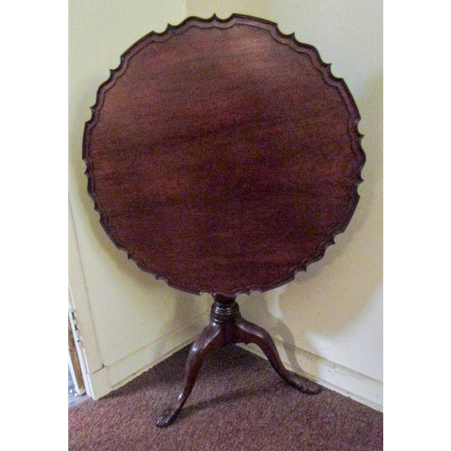 This outstanding large size period Chippendale English mahogany tilt-top table features a hand carved piecrust top on a...
