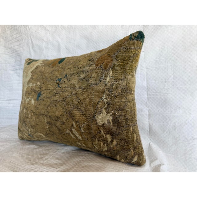 This 17th century Brussels tapestry pillow fragment features a traditional verdure composition rendered in the Baroque...