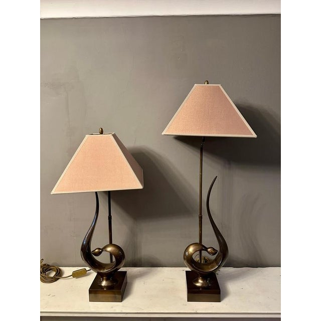 A pair of stylised and organic patinated brass table lamps, with gold fabric shades. The shade carrying arm is able to...