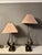 A pair of stylised and organic patinated brass table lamps, with gold fabric shades. The shade carrying arm is able to...