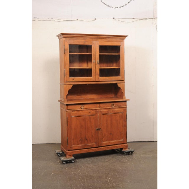 A tall French two-piece wooden cabinet from the 19th-century. This antique cabinet from France, often referred to as...