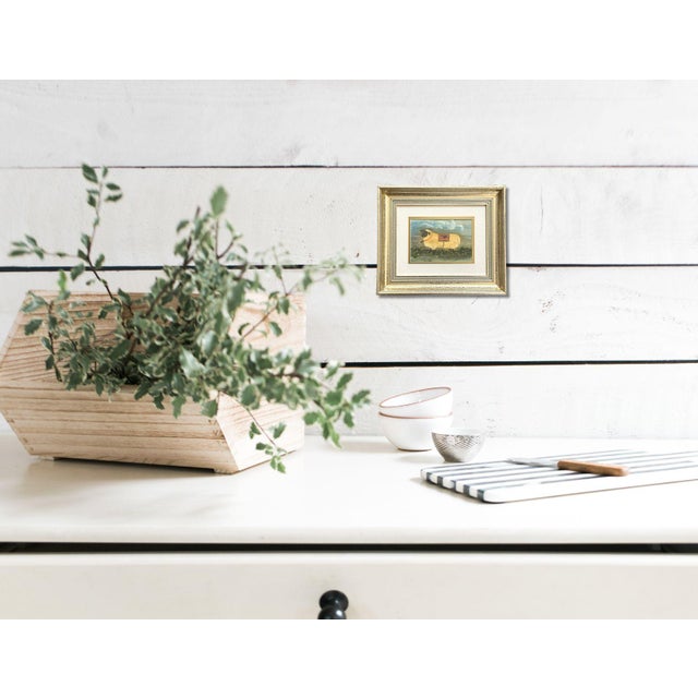 A delightful Folk Art painting of a whimsical sheep adorned with a heart-accented blanket, set against a charming pastoral...