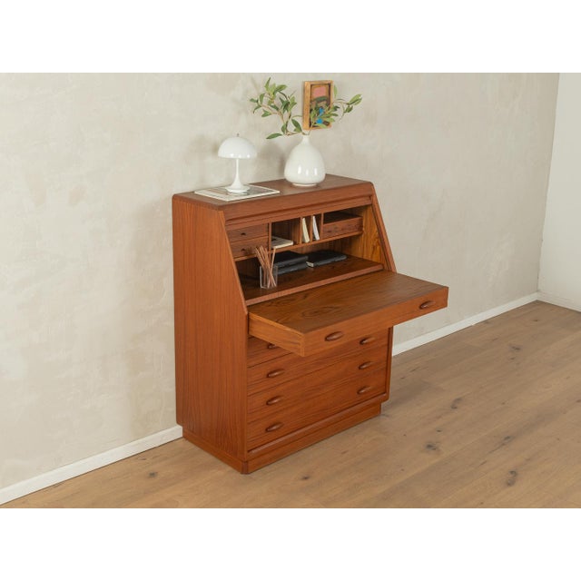 A classic secretary desk from the 1980s. High-quality solid teak body with four drawers, a pull-out work surface, five...