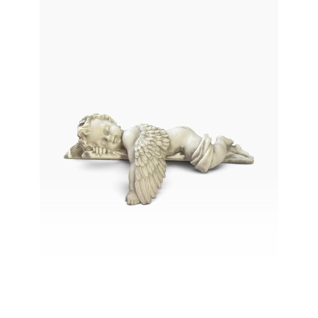 Peaceful sleeping cherub angel sculpture by Design Toscano, depicting a curly-haired young angel resting peacefully on his...