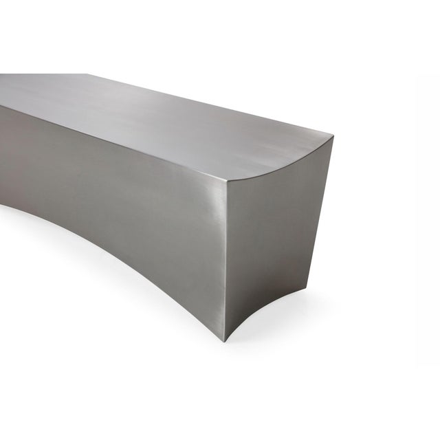This is the Sculptural l Modern Rectangular Bench, featuring a dramatic brushed stainless steel finish and concave edge