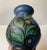 Unusual art deco earthenware vase decorated with flowers in matte cow-horn applied glazes over a blue background. Made at...