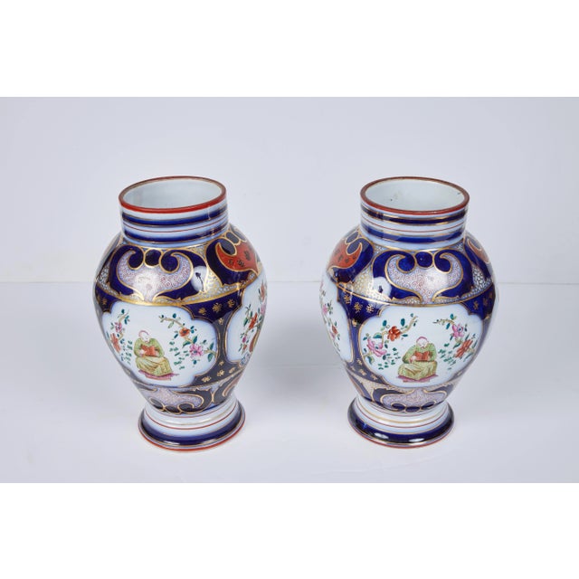 A beautiful pair of porcelain vases with a hand painted and gilded glazed overlay.