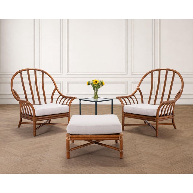 A beautifully crafted pair of bent pole rattan Organic Modern lounge chairs and matching ottoman made by artisans at...