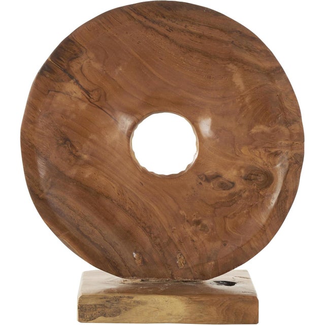 This abstract teak wood sculpture features a striking circular design with a carved center cutout, creating a bold yet...