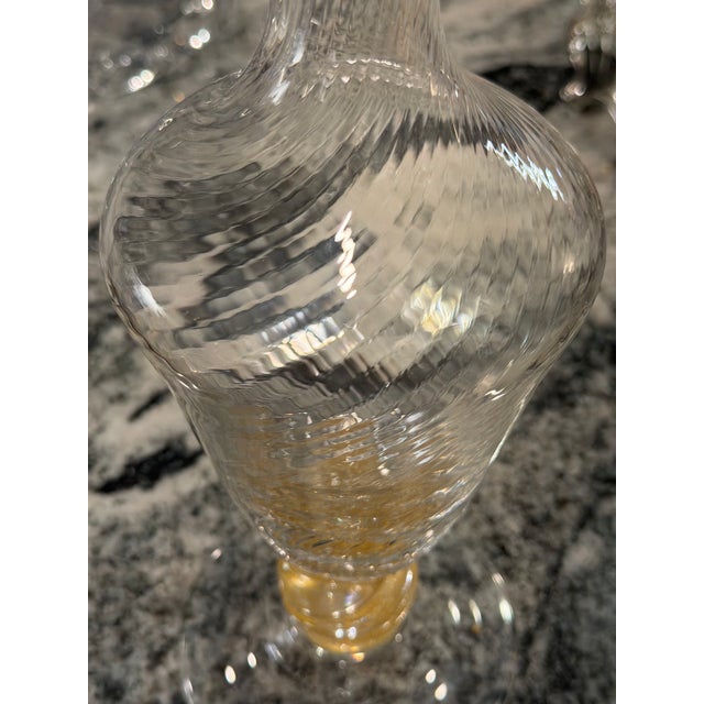 A beautifully hand-blown vintage art glass decanter featuring an elegant optic-twist body, oversized spherical stopper,...