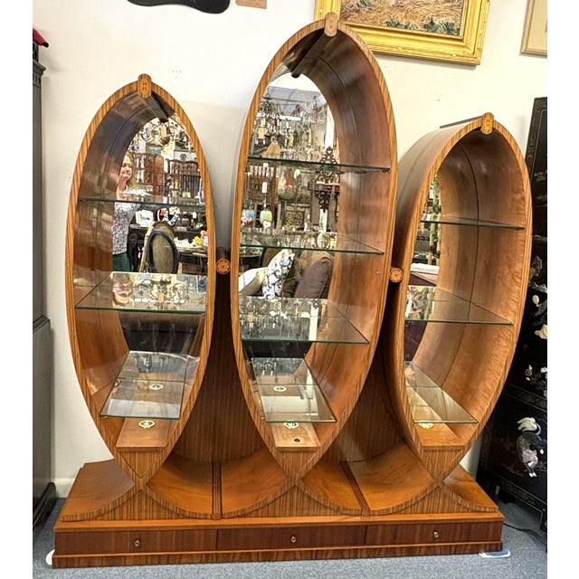Very unique wood and glass display cabinet from the late 20th century. The piece has a wonderful fan and feather shape...
