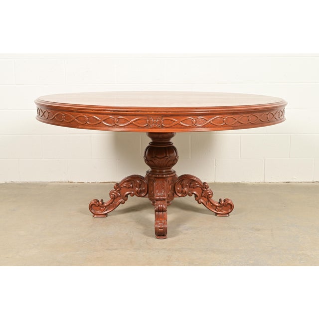 An outstanding antique Victorian or Renaissance Revivial carved mahogany pedestal dining table or center table In the...