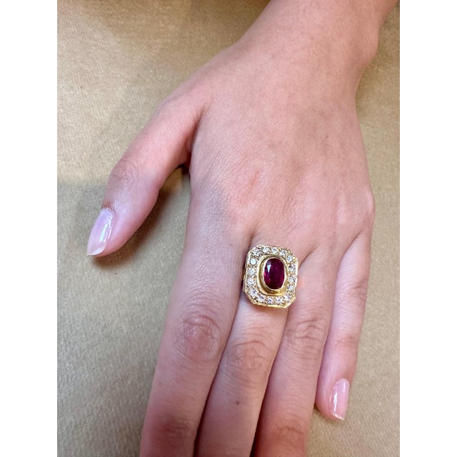Introducing our exquisite 18 Karat Gold Ring, featuring a stunning 1.4 carat natural oval Ruby and approximately 0.80...