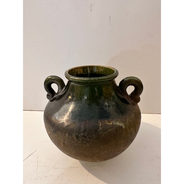 Beautiful ceramic vessel with handles. Signed on bottom but hard to determine what it says. It has a mostly greenish...