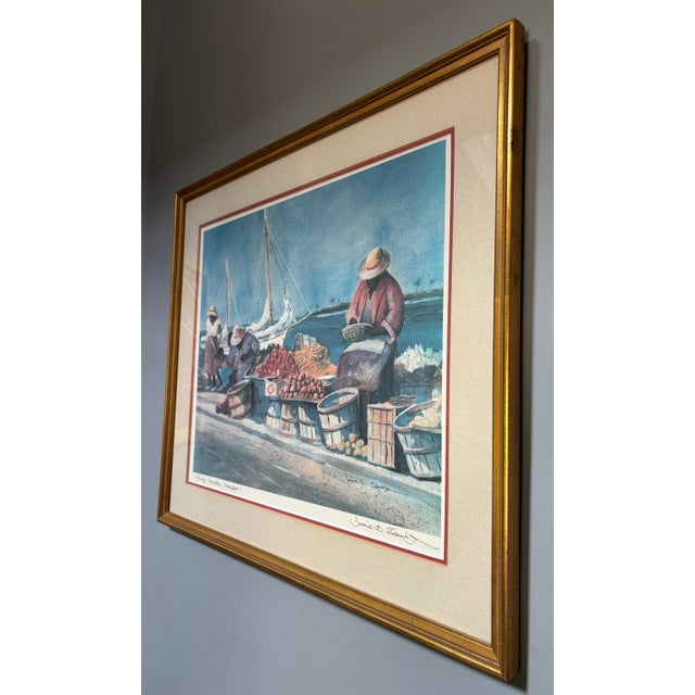 David W. Clough signed Lithograph “Sunny Caribbee Market” matted and framed in a gold toned wood frame beneath glass wired...