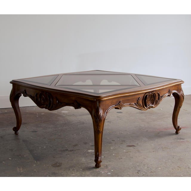 A carved Louis XV–style square cocktail table with a smoked beveled glass top set in a harlequin pattern: a center diamond...
