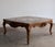 A carved Louis XV–style square cocktail table with a smoked beveled glass top set in a harlequin pattern: a center diamond...