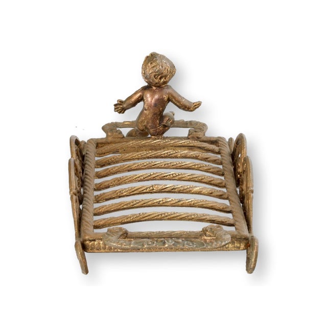 French ormolu gilt cherub sponge or soap holder featuring a sculptural cherub figure set within an ornate openwork frame....