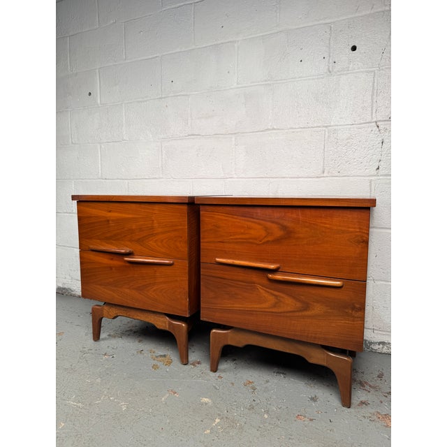 Handsome pair of mid-century nightstands showcasing rich grain and clean modern lines. Each piece offers practical storage...