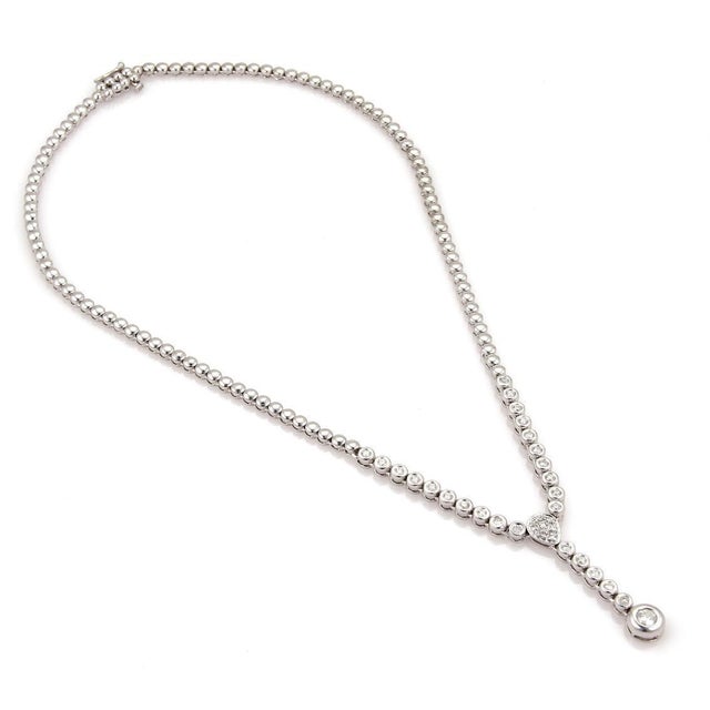 This lovely lariat style necklace is crafted form 14k white gold with a high polished finish. The front centerpiece had...
