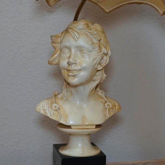 This lamp makes use of a bust by the sculptor Santi. It is a signed recast of his work and makes this mid century modern...