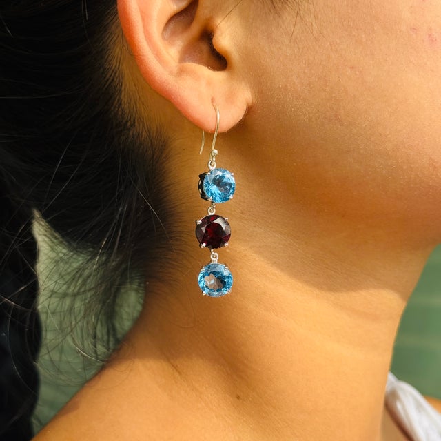 Crafted in 925 Solid Sterling Silver, these dazzling dangle drop earrings showcase the captivating beauty of Garnet and...