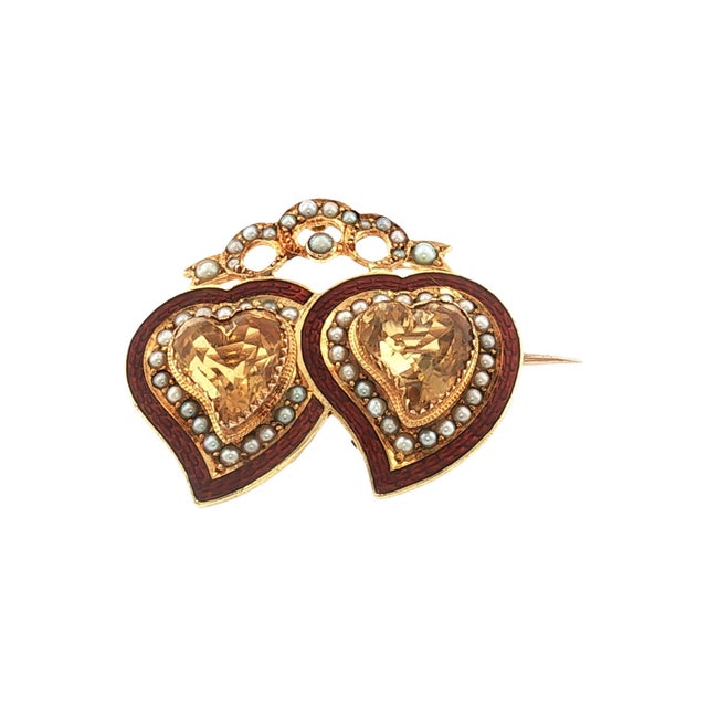 A late 19th-century brooch crafted from 15k gold. Features two heart-cut natural yellow topaz stones. A crowned double-...