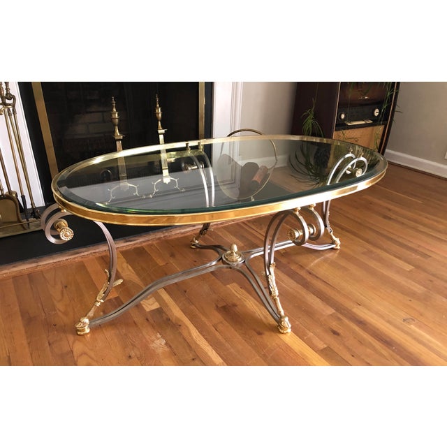 Gorgeous vintage Maison Jansen style neoclassical, oval, brushed steel and brass, coffee or cocktail table, featuring...