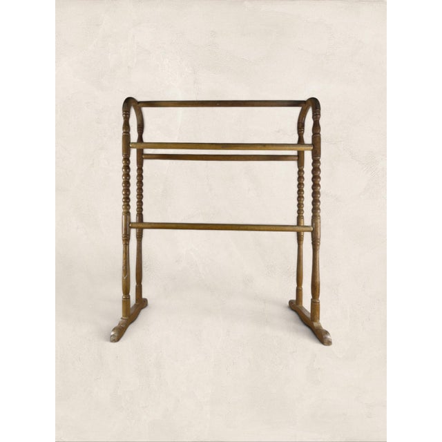 A charming antique English pine clothes horse dating to circa 1900, featuring beautifully turned spindle supports, gently...