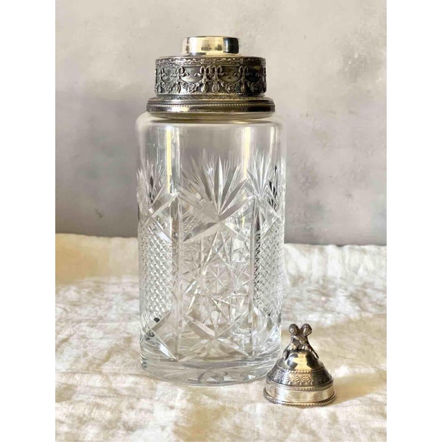 A refined vintage cocktail shaker featuring a cylindrical body in thick cut crystal. The glass is distinguished by its...
