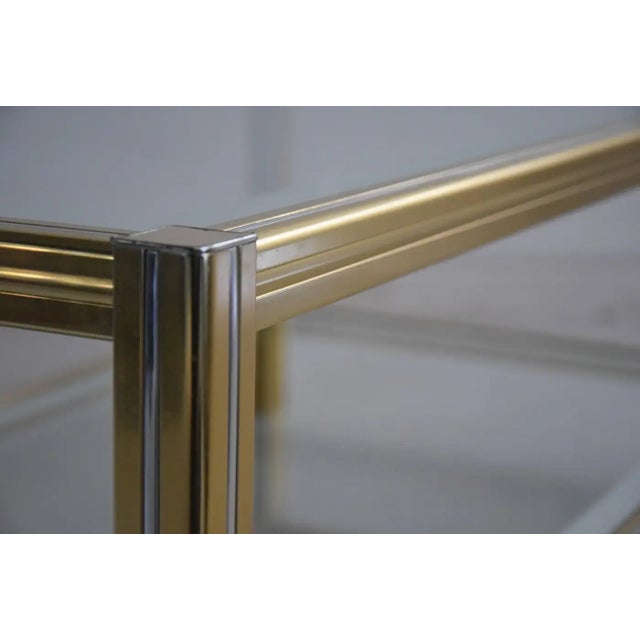 Brass and chrome two tier coffee table. Hollywood Regency. Glass has mirrored borders. Similar to: Pierre Vandel...