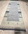 A hand-loomed wool rug, made in India and measuring 4' x 6'. Geometric drawing - repeating motifs held inside strong...