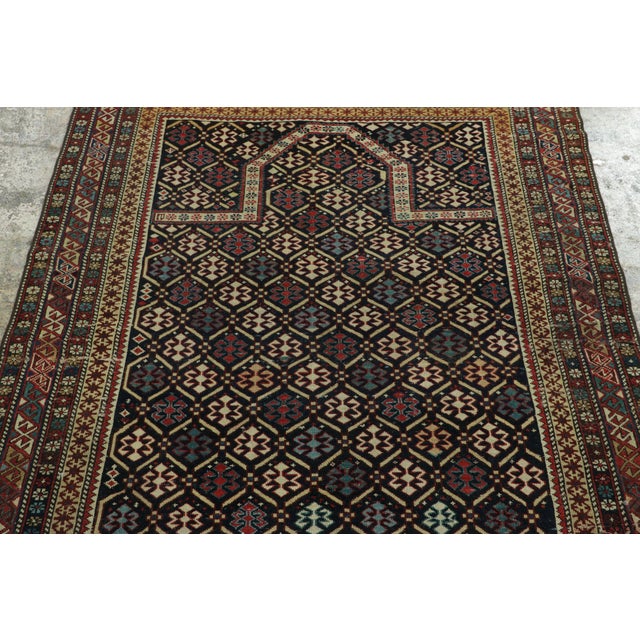 Hand-knotted in high-quality wool and originating from Russia circa 1900-1920, this 4x5 antique square Kuba rug is a...