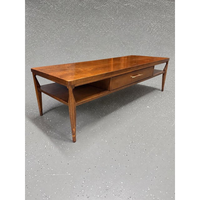 A striking vintage coffee table from Broyhill’s sought-after Saga Collection, dating to the 1960s. Crafted in warm walnut,...