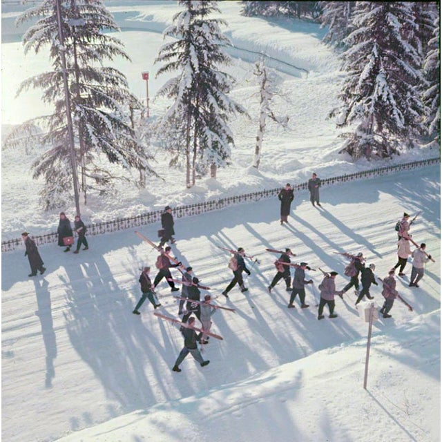 Setting Out by Toni Frissell A group of skiers walk through the street on their way to the ski runs, Klosters,...