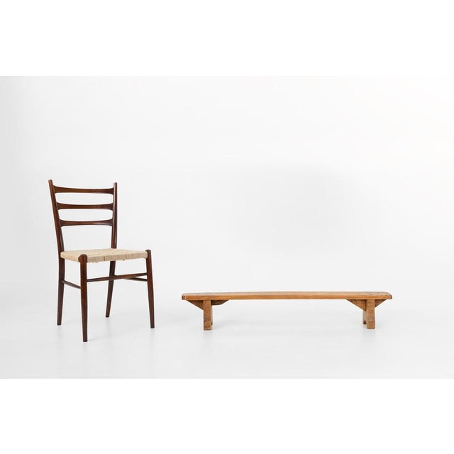 A characterful French wooden bench dating to around 1850, showcasing the honest, timeworn charm of rural craftsmanship....